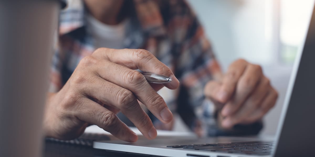 Hands typing on a laptop